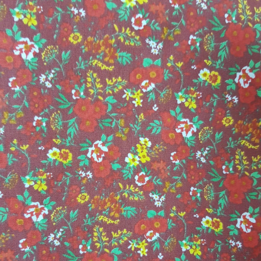 Floreada flor roja sobre fondo bordó